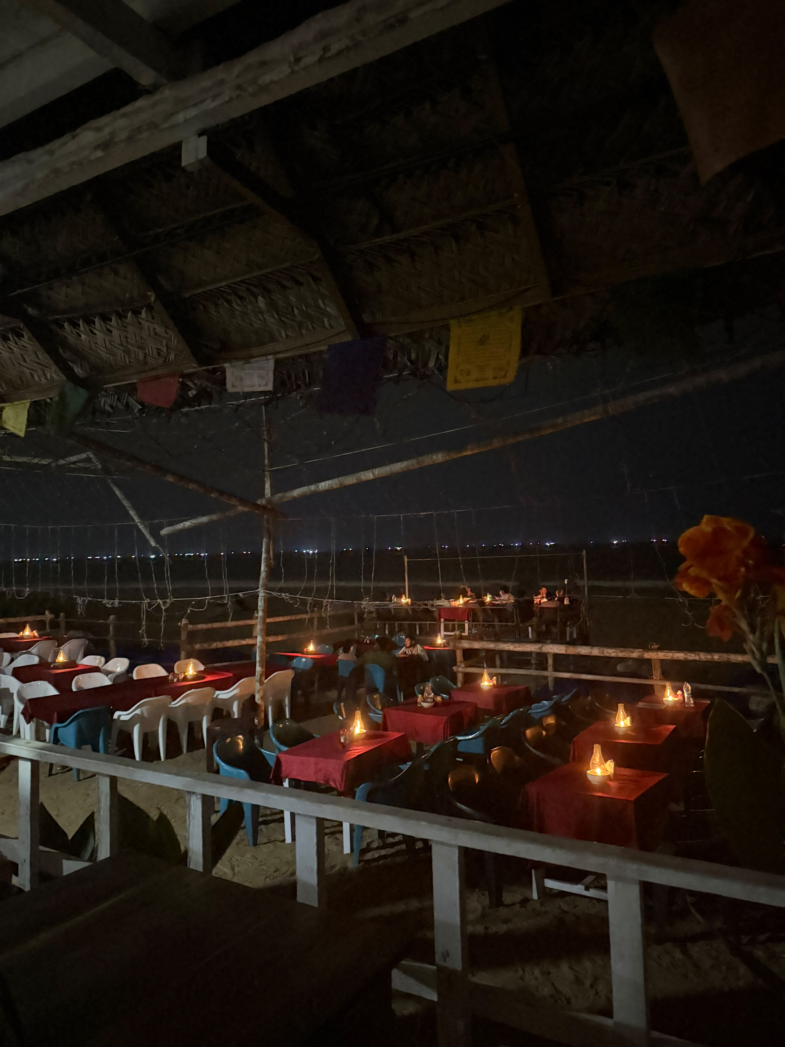 Candlelit tables by the sea at night